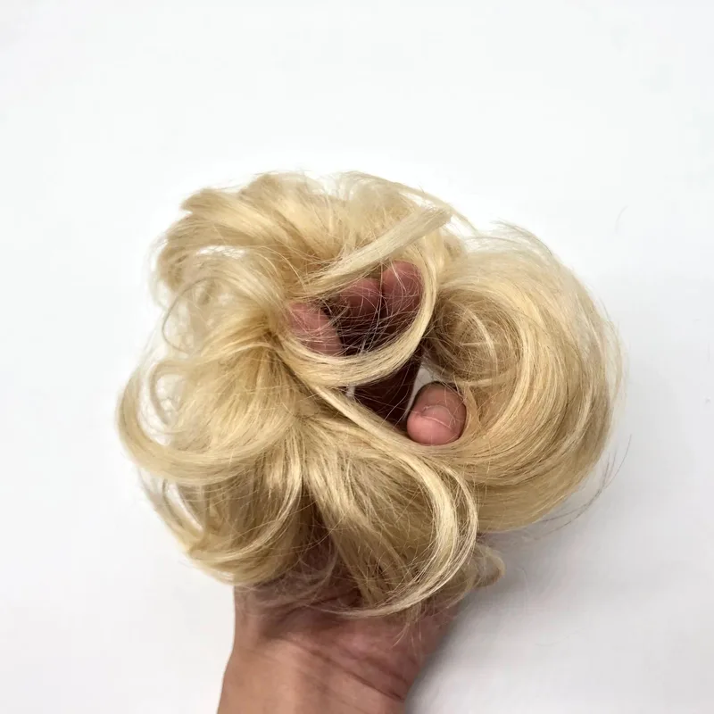 Blonde human hair piece for ponytails and up-dos held in one hand
